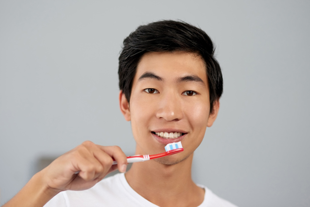 A guy is using the toothpaste for sensitive teeth