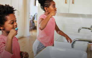 wanita duduk di hadapan komputer riba sambil tersenyum